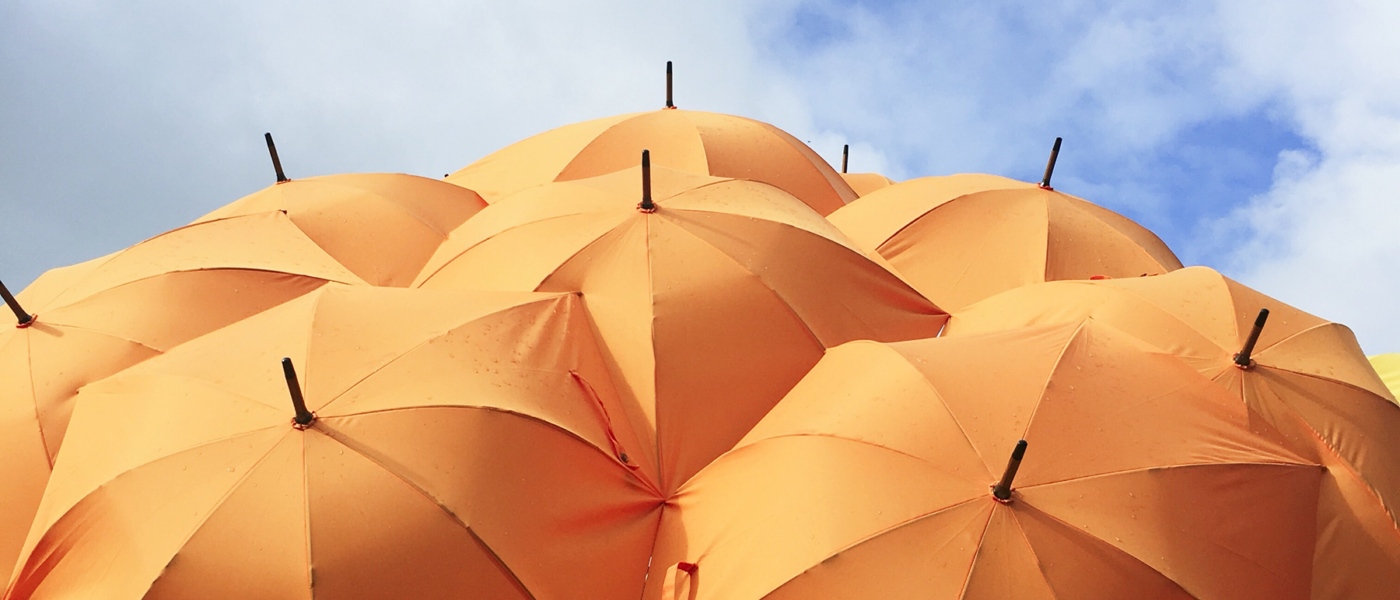 a collection of open orange umbrellas overlapping each other.